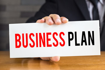 Business plan, message on white card and hold by