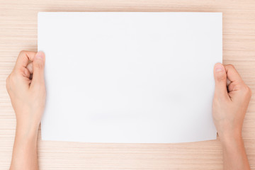 Obraz premium Hands holding paper on wooden background