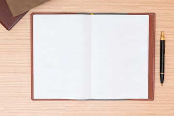 Blank notepad with office supplies on wooden table. Above view.