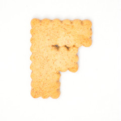 letter F made of cracker cookie isolated on white background.