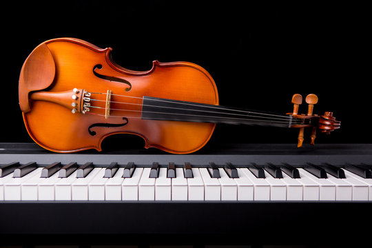 Violin on the piano on a black background