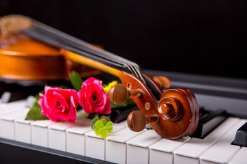 Fototapeta premium Violin on the piano on a black background