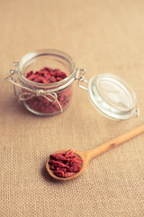 Dry red goji berries in wooden spoon on rustic background for a healthy diet. The toning.