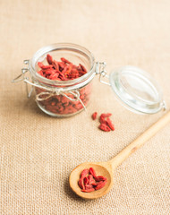 Dry red goji berries in wooden spoon on rustic background for a healthy diet.