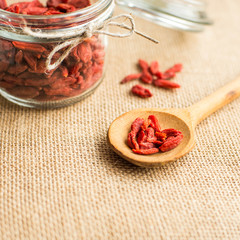 Dry red goji berries in wooden spoon on rustic background for a healthy diet.