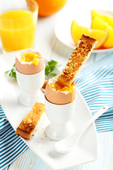 Boiled egg with toasts on a blue wooden table