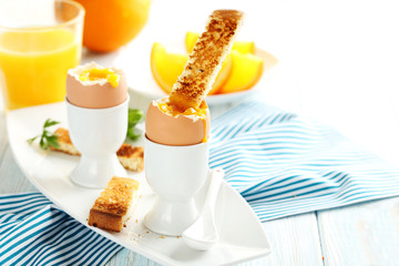 Boiled egg with toasts on a blue wooden table