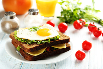 Fried eggs with toasts on plate on blue wooden table