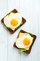 Fried eggs with toasts on blue wooden table