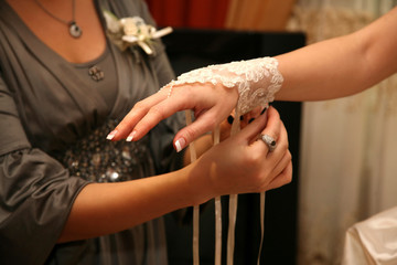Obraz na płótnie Canvas bridesmaid helps the bride to wear a bandage on his hand