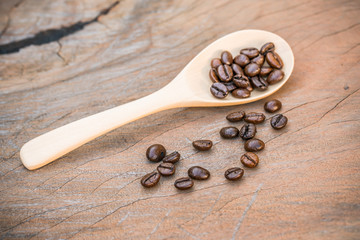 close up of Coffee beans with wooden spoon on grunge wooden background