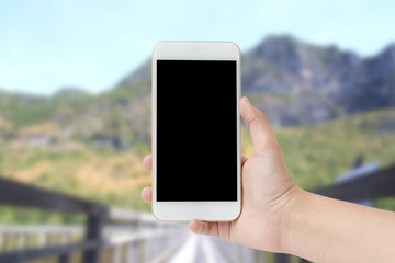 Woman hands shows mobile smartphone in vertical position, blurre