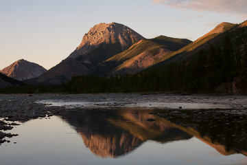 Mountain expressive form and its reflection in the river. River Omulyovka. Magadan Region. Russia.