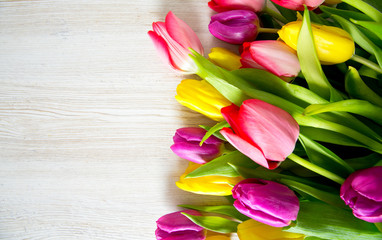 colorful tulips on wooden surface