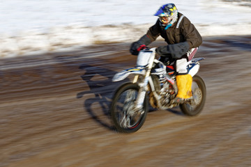 Motorcyclist racing in the winter track.