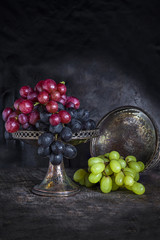 Variety of grapes on dark background- vintage, moody style