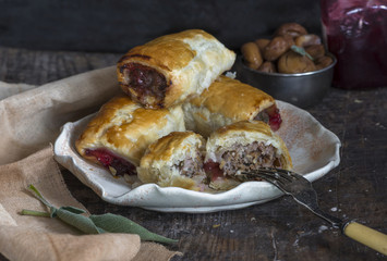 Homemade pork sausage rolls with chestnuts, cranberry sauce and sage