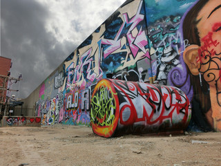 Painted industrial metal barrel in urban setting with ominous sky - landscape color photo