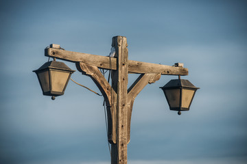 old fashioned wooden street light with two lamps