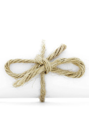 Handmade natural cord node tied on white paper roll isolated