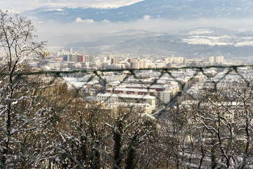 View of mountain city through fence