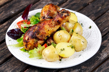 Baked chicken legs with potatoes and vegetables