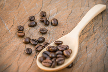close up of Coffee beans with wooden spoon on grunge wooden background