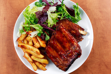 Roasted Pork Rib,  Fried Potato on white plate with Vegetables.