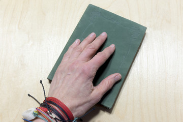 Hand on green journal over table