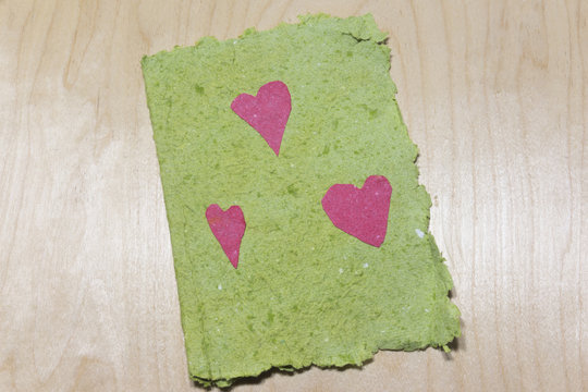 Homemade green paper with pink hearts
