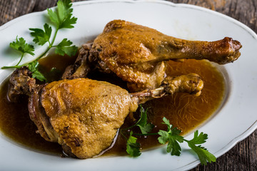 Roasted duck legs on white plate