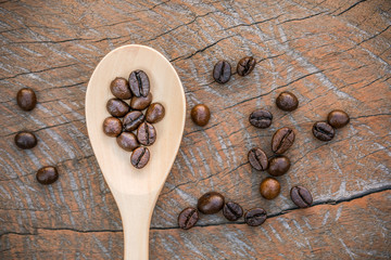 close up of Coffee beans with wooden spoon on grunge wooden background