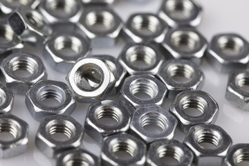 abstract background metal nuts closeup on white