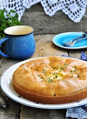 Snack cake with chicken, potatoes and green onions on a wooden background. selective focus.