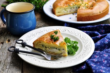 Snack cake with chicken, potatoes and green onions on a wooden background. selective focus.