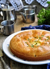 Snack cake with chicken, potatoes and green onions on a wooden background. selective focus.