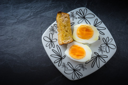 Huevos cocidos partidos en dos con pan tostado