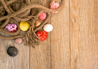 rope seashells and stones on a wooden background