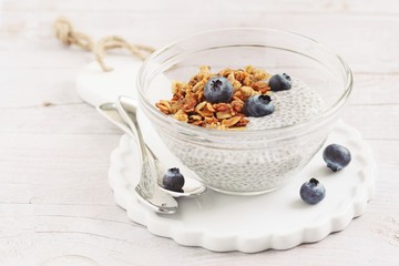 Superfoods concept : overnight chia pudding with homemade granola,fresh berries and honey. Healthy eating. Selective focus.