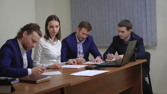 Two business people in elegant suits. Working in team together with documents sign up contract. 