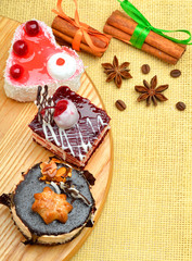 Cakes and cinnamon sticks on tablecloth