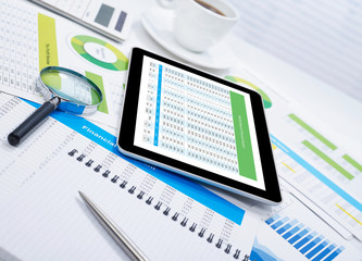 Obraz premium Tablet on desk and financial papers
