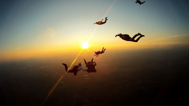 Skydivers playing at the sunset
