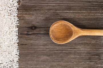 rice and wooden kitchen spoon on wooden table