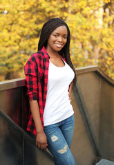 Pretty smiling african woman wearing a red checkered shirt in ci