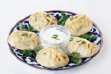 manti ravioli large dumplings plate with sour cream and dill isolated white background
