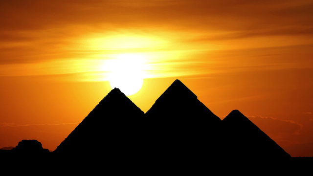 Sun goes behind great pyramids in Giza valley during gorgeous sunset, Egypt