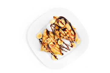 Pancakes with banana, ice cream and chocolate dressing - Top view