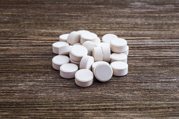 Fototapeta na wymiar Medical pill on wooden table. Close up photo