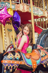 Beautiful young girl on a merry go round